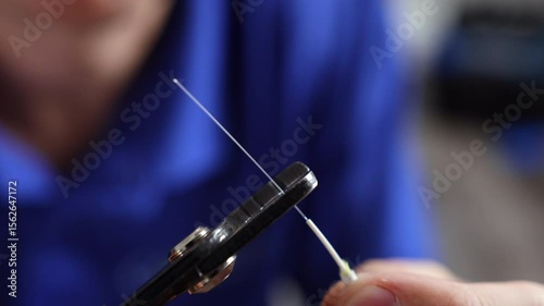 A fiber technician strips and cleaves an optical fiber cable using a precision stripping tool