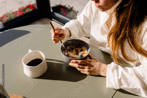Responsible vacationer enjoys a bowl of organic fruit and coffee