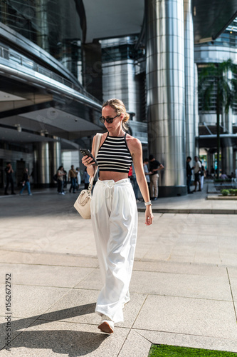 Connected lifestyle female walking with smartphone
