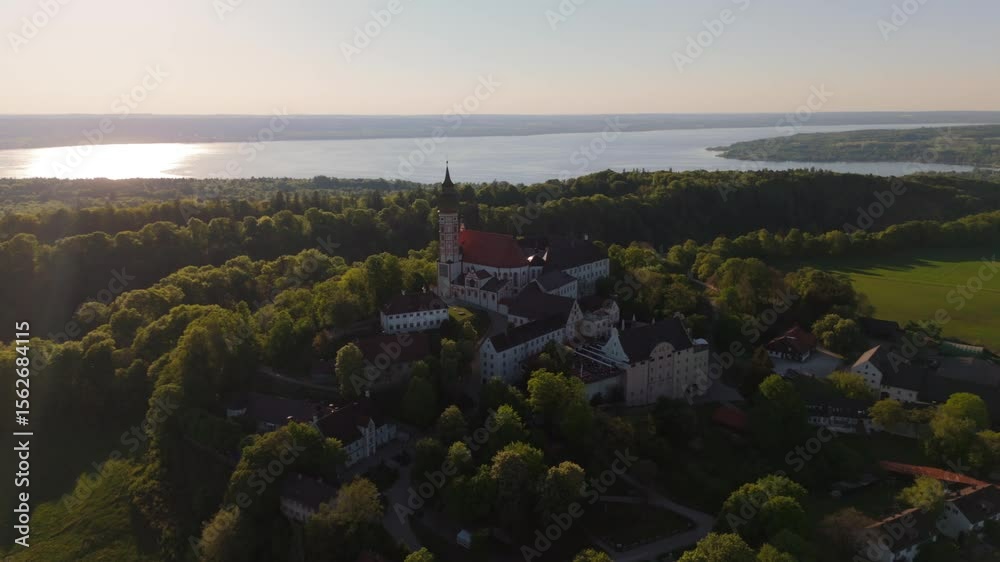 Drone footage of Kloster Andechs on Holy Mountain in Upper Bavaria, Germany. View of monastery, baroque church, lake Ammersee and green countryside near Munich at golden hour. Luftbild Heilige Berg. 