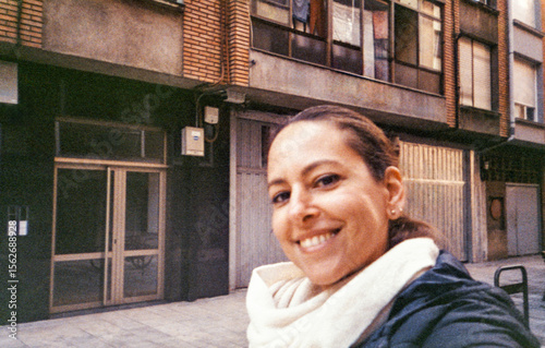 Analog selfie of a woman bundled up on a city street