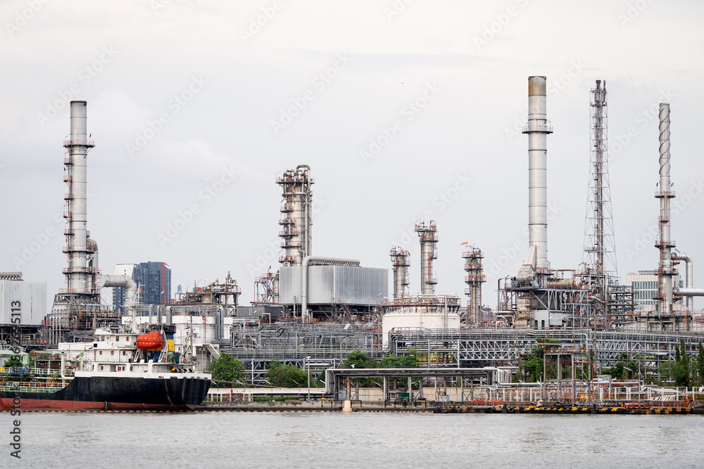 A shipping boat docked at a power plant and a shipping port in Bangkok A shipping boat docked at a power plant and a shipping port in Bangkok