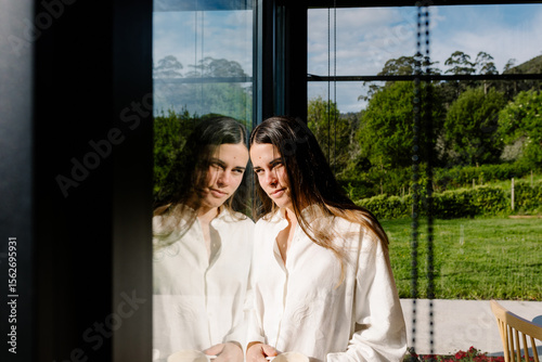 Portrait of a woman gazing thoughtfully through a large window