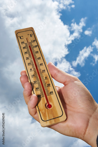 Hand Holding Thermometer in Sunny Weather
