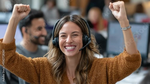 Triumphant support agent: A female support agent celebrates a victory, her arms raised in triumph, headset still on, her face radiates joy amidst a busy office environment.