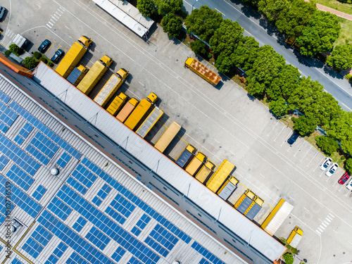 Aerial View of Factory with Solar Panels and Transport Trucks