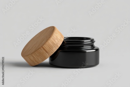 A close-up of a ceramic jar filled with black and white paint, featuring a stylish wooden lid. The minimalist design adds a touch of elegance to any art studio or workspace.