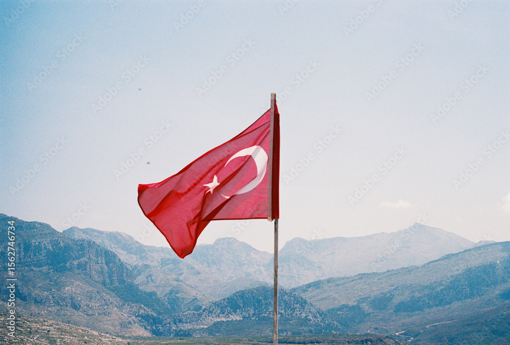 Turkish flag waving with mountains in the background Turkish flag waving with mountains in the background