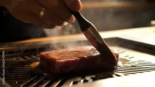 Grilling steak with basting sauce, and closeup.
