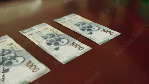 Money $1000 peso bills on a wooden table