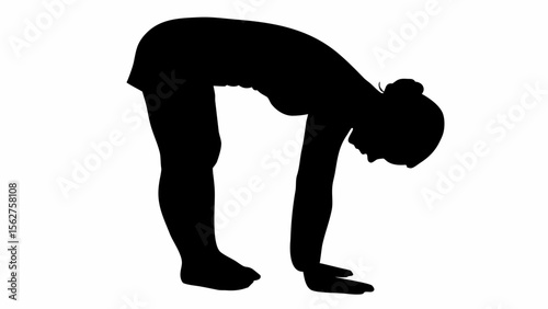 Silhouette of a woman in a standing forward bend yoga pose with hands on the floor and head down low