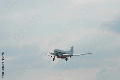 Military plane flying through the sky and clouds on nature background