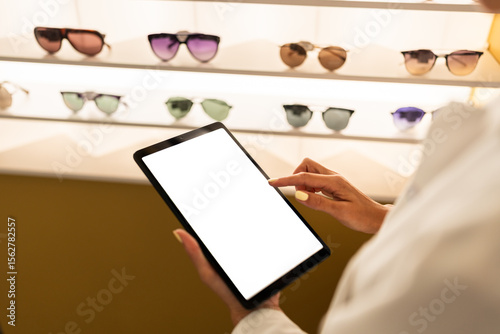 Optician using digital tablet with blank screen in optical store
