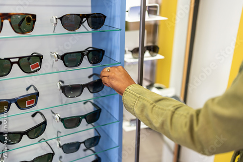 Woman choosing sunglasses in optical store