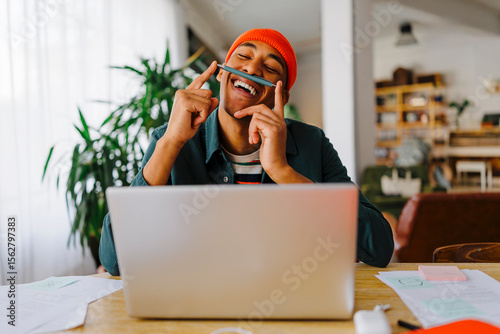 Man balancing pen on upper lip at desk