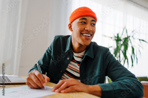 Smiling man doing homework at bright living room