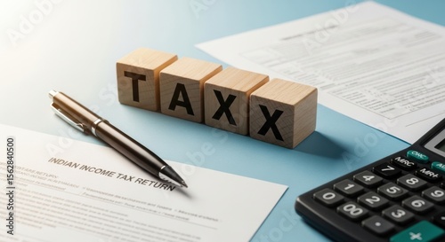 Wooden blocks spelling tax with indian income tax return form pen and calculator