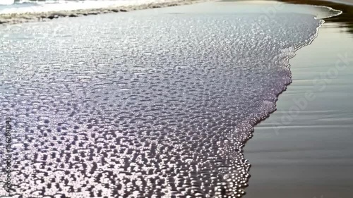 Ocean waves on wet beach sand