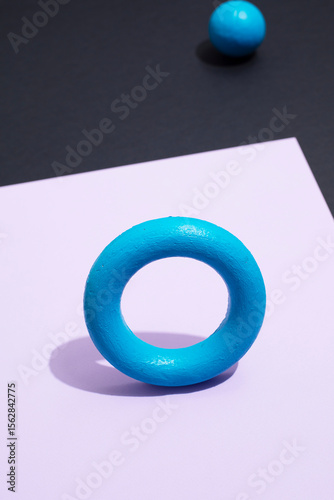 Still life image of colourful geometric rings with strong shadows