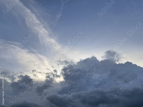 Evening sunset – White and dark clouds illuminated by the last remaining rays of the evening sun, amidst a darkening blue sky.