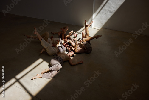 Group of dancers engaged in collaborative movement under natural