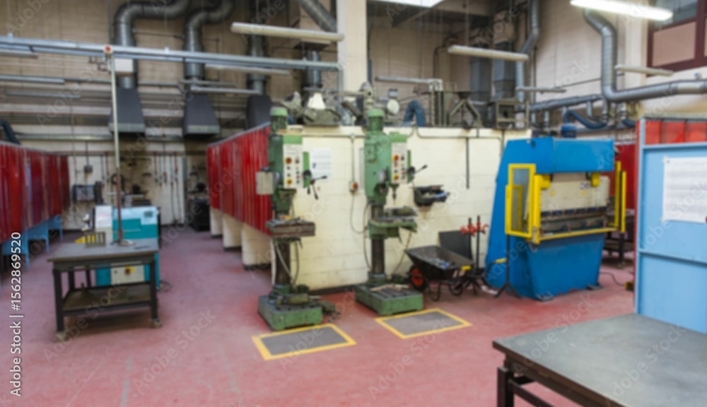 Naklejka premium Green drill presses are standing in flat design workshop, showcasing blue press and red partitions