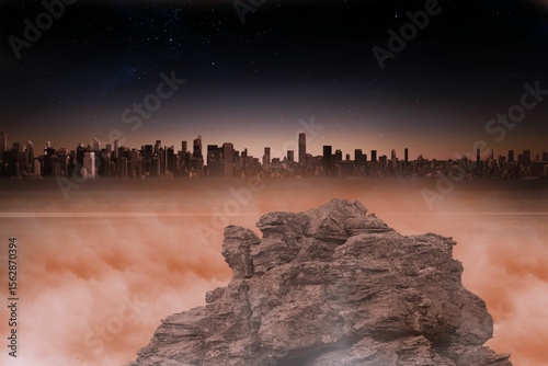 Rock formation is rising above orange clouds and distant skyline is glimmering under starry sky