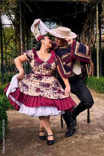 A couple of young Chilean Latin dancers posing romantically and dancing the cueca in a very cheerful, charismatic, and affectionate manner. Chilean Independence Day celebration.