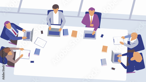 Overhead view of a business meeting with people around a table with laptops and documents present