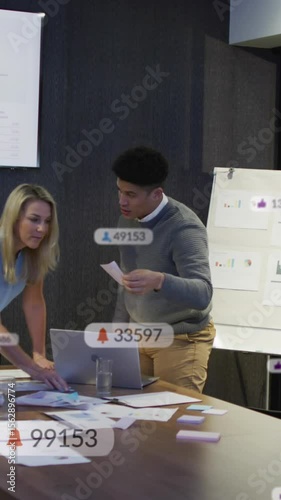 Anmation of social media icons against diverse colleagues discussing over documents at office