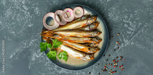 Canvastavla Plate with delicious smoked capelin on grey grunge background