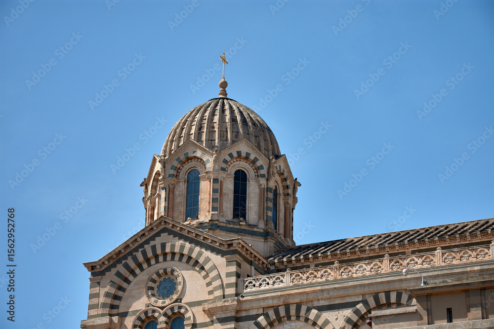 Obraz premium Dome and architectural details of Notre Dame de la Garde in Marseille, France, under a clear blue sky and intense natural light