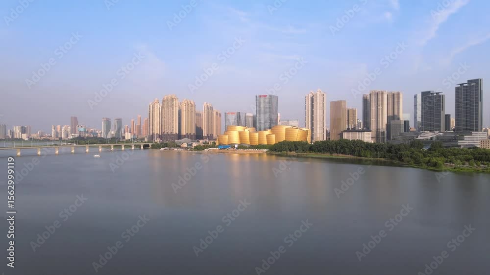 Expansive aerial view of bustling city business district and shopping center along serene waterfront Expansive aerial view of bustling city business district and shopping center along serene waterfront