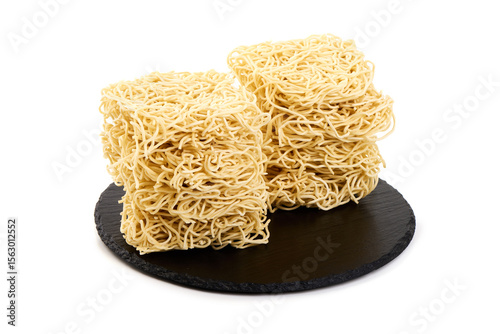Egg Noodles Stacked on Slate, isolated on white background