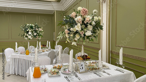 Elegant banquet table with a flower arrangement centerpiece, fresh salads, and fruit platters. Perfect for upscale events such as weddings, parties, or corporate gatherings with a luxurious touch