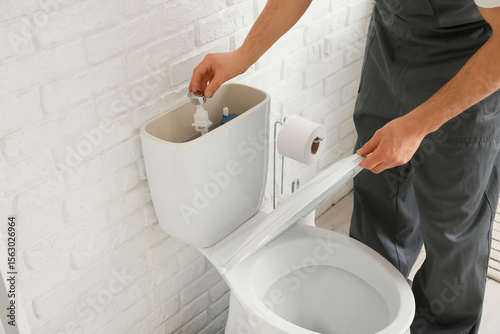 Male plumber repairing toil...