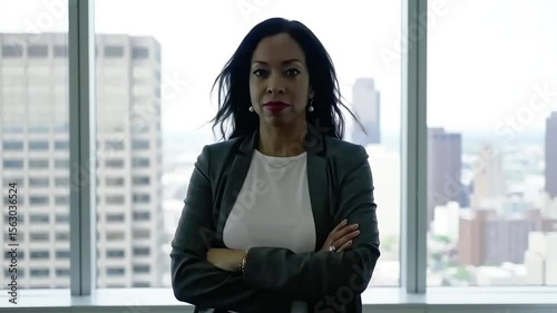 Confident businesswoman standing in office with city view