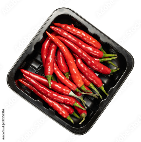 Fresh red cayenne chili peppers on black tray isolated against dark background, vibrant spicy raw vegetable, culinary ingredient, fiery hot flavor enhancer