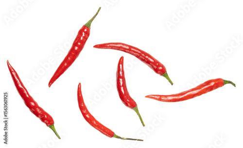 Fresh vibrant red cayenne chili peppers with glossy texture and green stems, isolated on black background, spicy hot cooking ingredient, raw vegetables for flavorful dishes