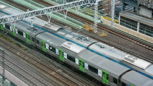 aerial top down view to the JR railway track way with JR Yamanote train commuters while moving through the city center of Tokyo in winter daytime