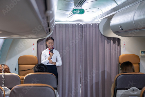 African flight attendant is greeting the passenger to welcome on board to the flight and reporting the attitude, weather and route to the destination airport