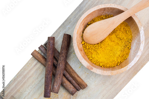 Fototapeta Naklejka Na Ścianę i Meble -  cinnamon sticks and powder in a wooden bowl with spoon isolated on white background