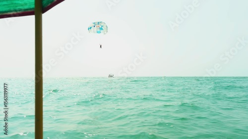 Traveler enjoy thrilling parasail ride in summer vacation