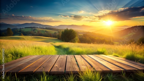 A breathtaking sunset over rolling green hills and a golden meadow with a wooden deck in the foreground, bathed in the warm light of the setting sun