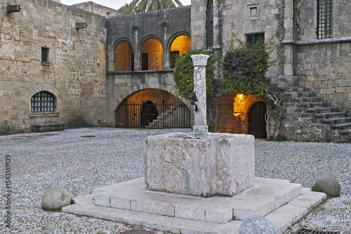 Billede på lærred Argyrokastro Square with central Byzantine fountain  made out of an early-Christian baptismal font and the medieval building at Rhodes old town