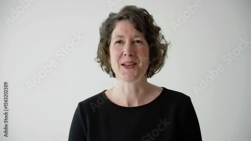 Confident woman speaking directly to camera on white