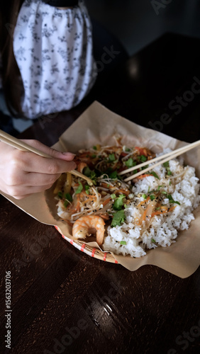 Close-up of Caucasian woman eating pan-Asian cuisine
