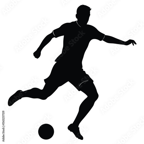Silhouette of a soccer player kicking a ball football