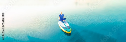 A man doing yoga on his SUP board and practicing mindfulness on his travel.