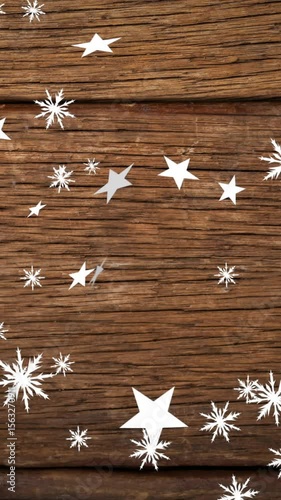 Animation of christmas stars falling over wooden background